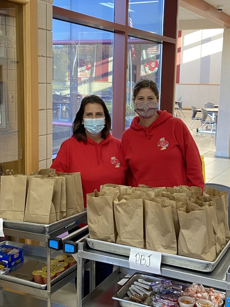 Cafeteria staff distributes to go meals for students